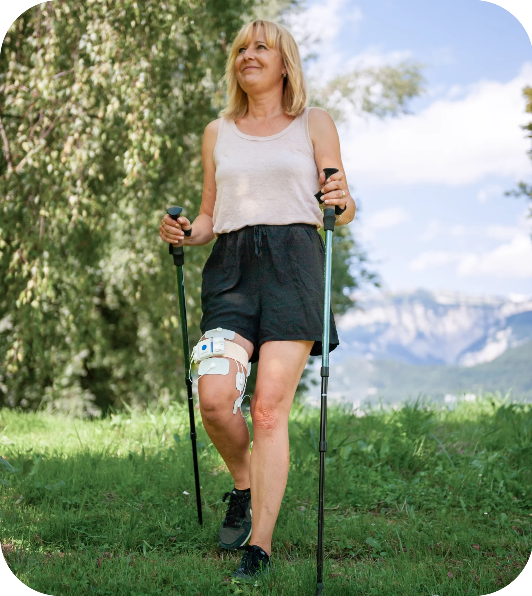 A woman wearing actiTENS on her knee to relieve knee pain during a hike.